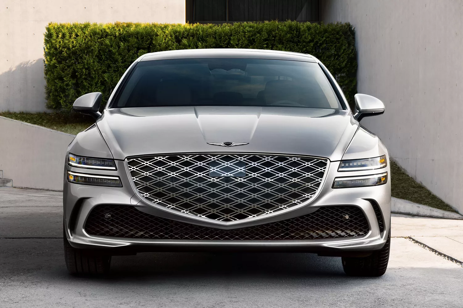 Front view of grille details on Genesis G80 in Ceres Blue parked in front of modern house