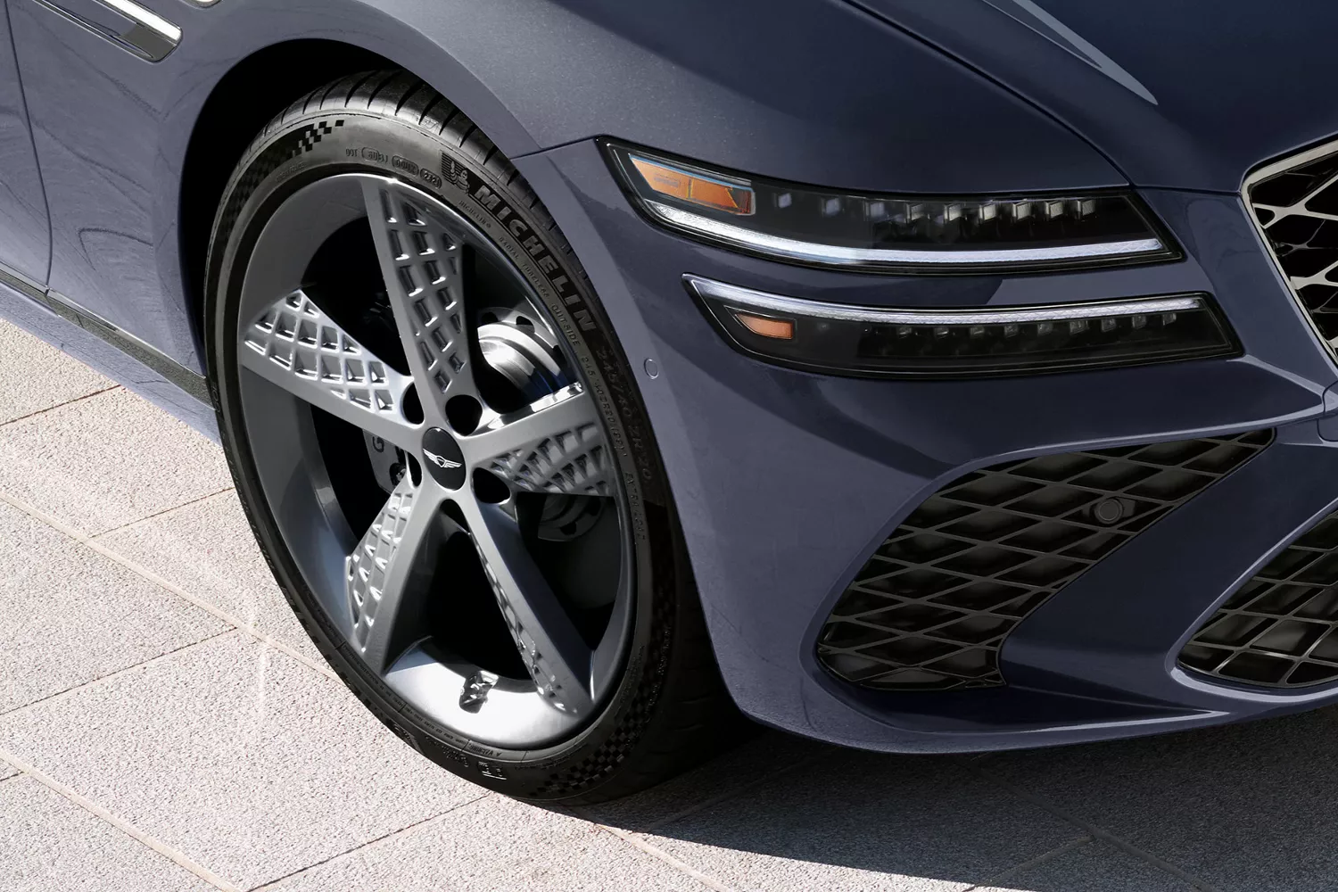 3/4 passenger side close up of wheel details on Genesis G80 in Ceres Blue
