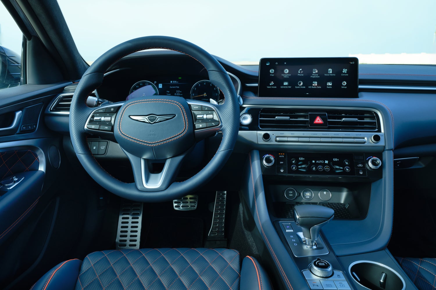 The steering wheel of the 2026 Genesis G70 in Phoenix is seen from the driver's perspective.