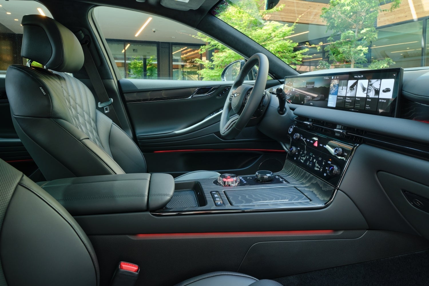 The obsidian black interior of the 2026 Genesis G80 is seen in full from the passenger seat looking towards the driver's area of the spacious cockpit.