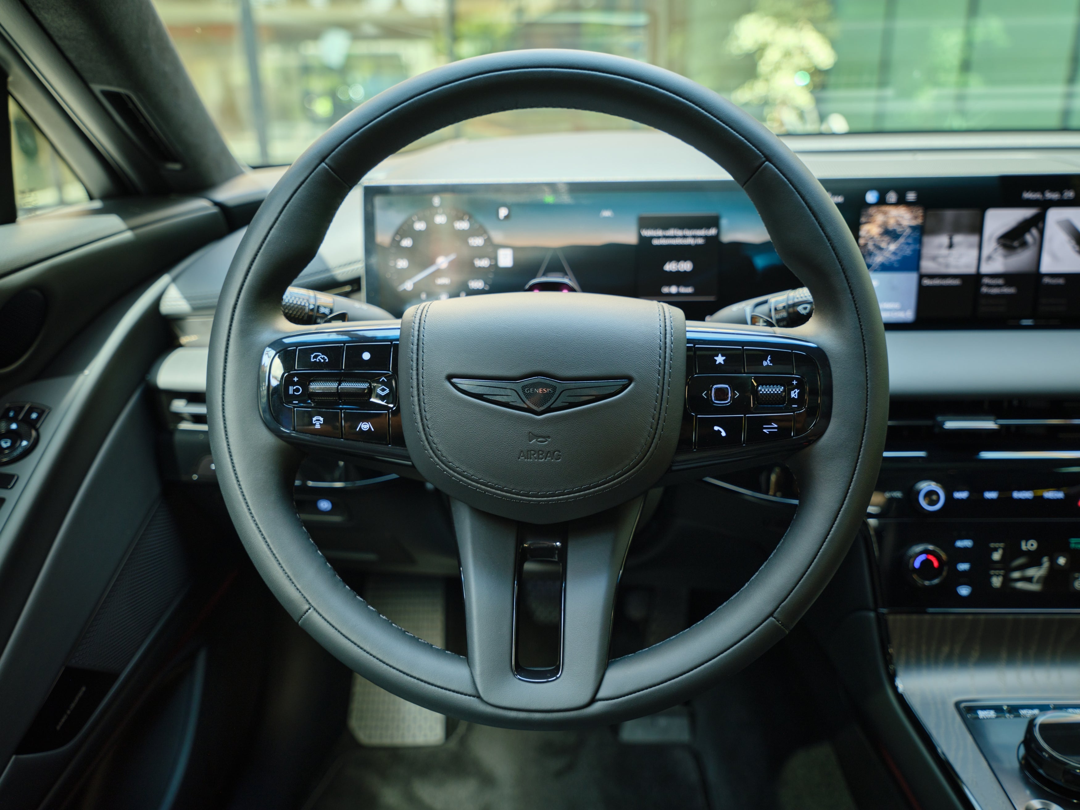 The steering wheel and dash technology of the new G80 in Phoenix is seen from the perspective of the driver.