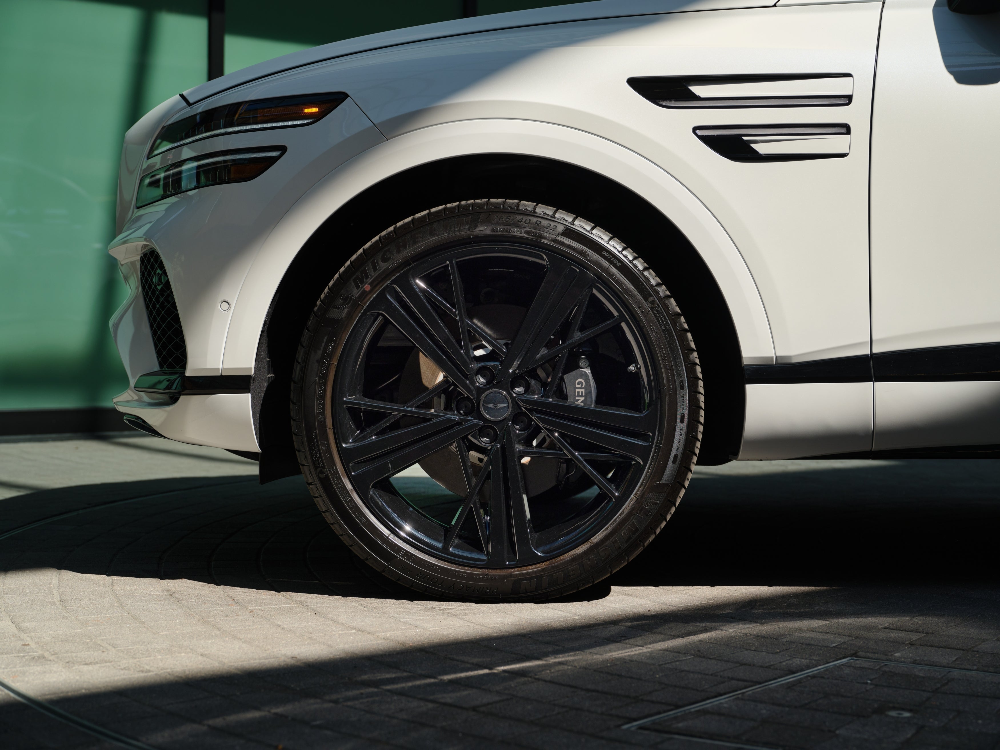 The front driver's side wheel of the 2026 Genesis GV80 Coupe is shown parked on pavement in Chandler.